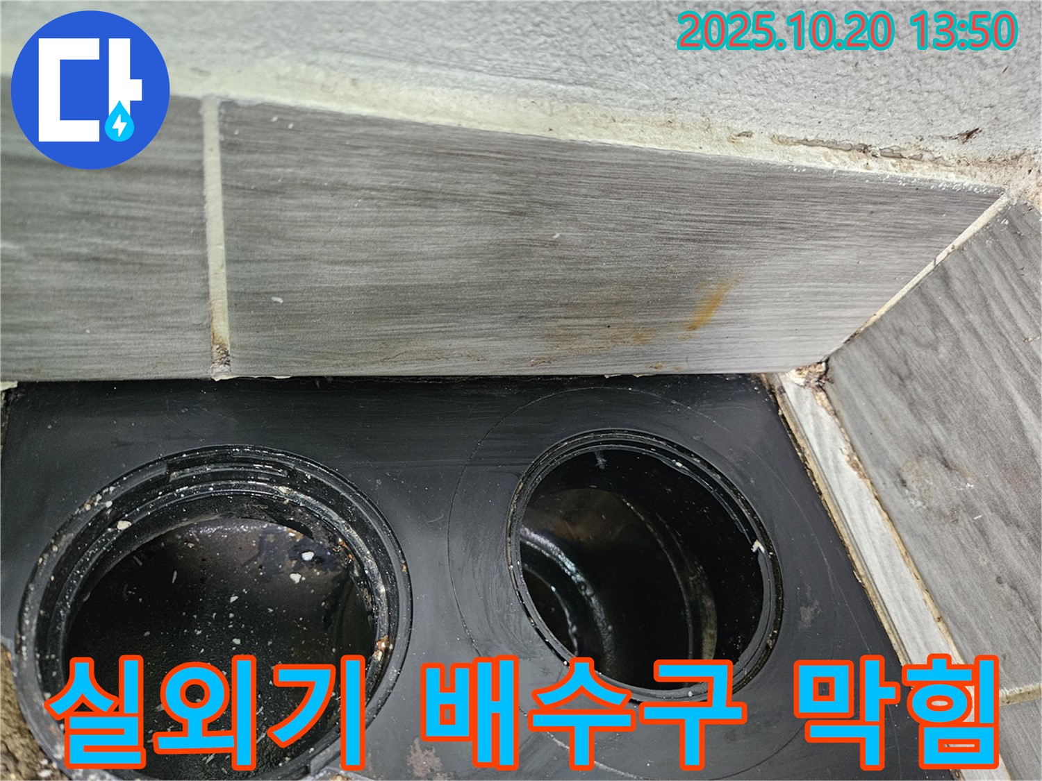 막힌 에어컨 실외기 배수구 - 물이 제대로 빠져나가지 못하고 고여 있습니다.