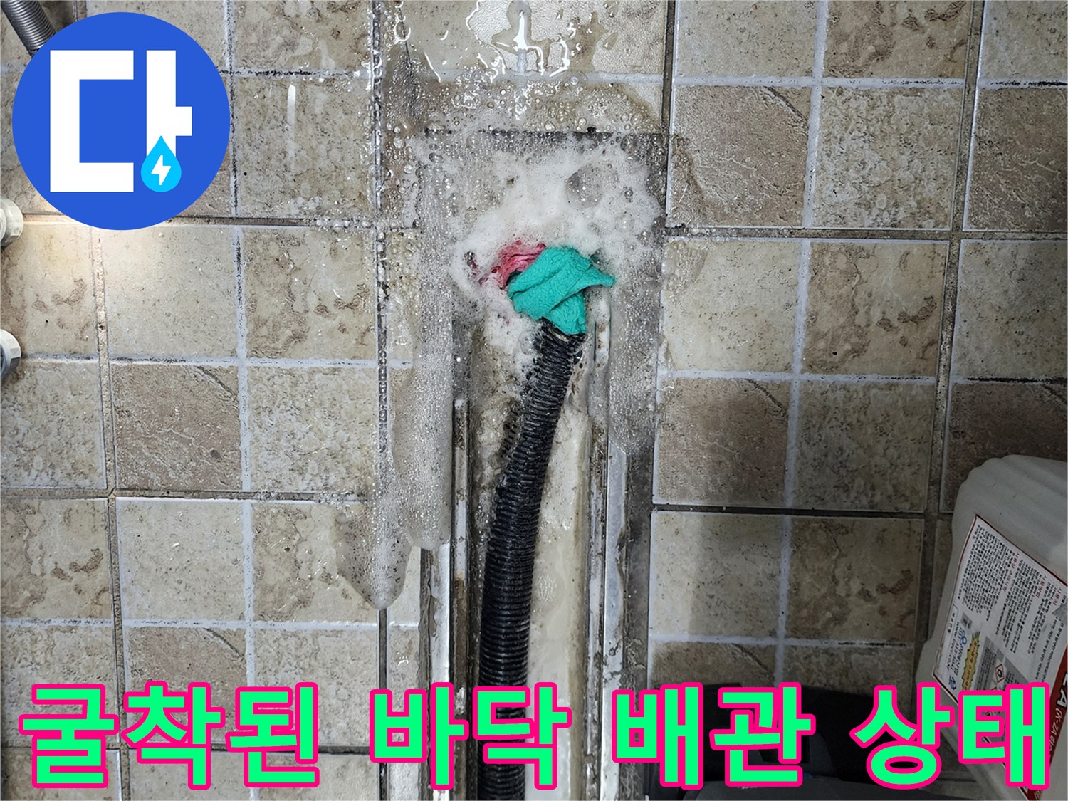 타일 아래 배수 호스 주변의 습기 및 물고임 현상 상세샷