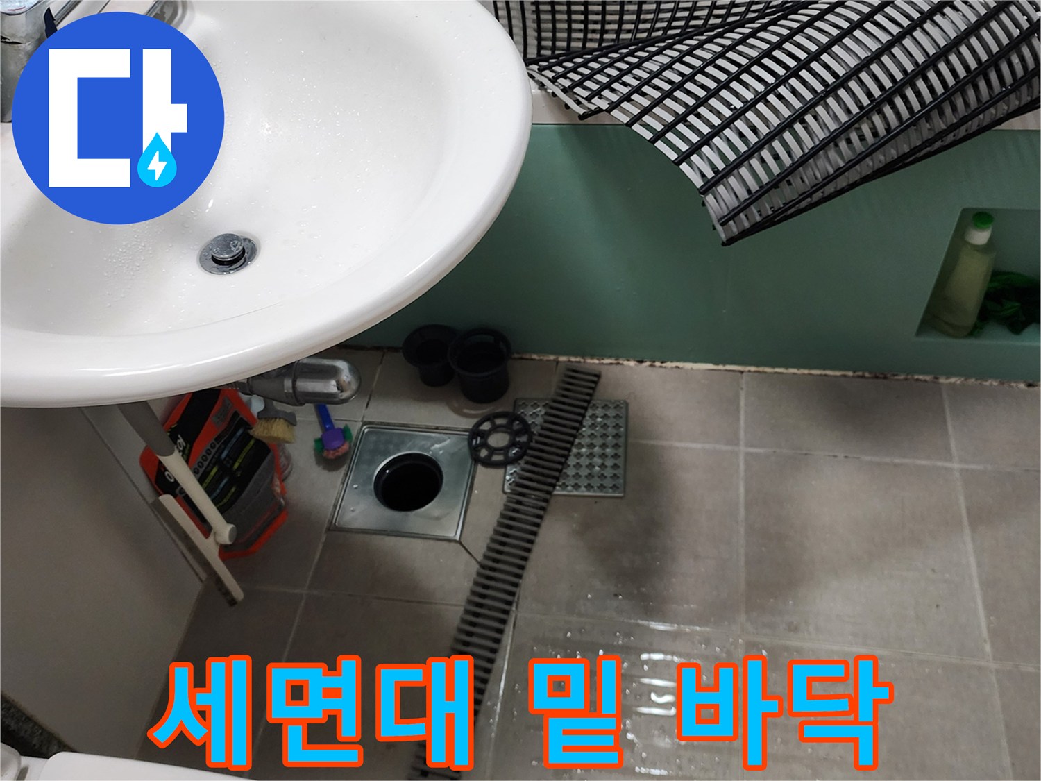 세면대 하단 타일과 긴 형태의 배수 트렌치 구조