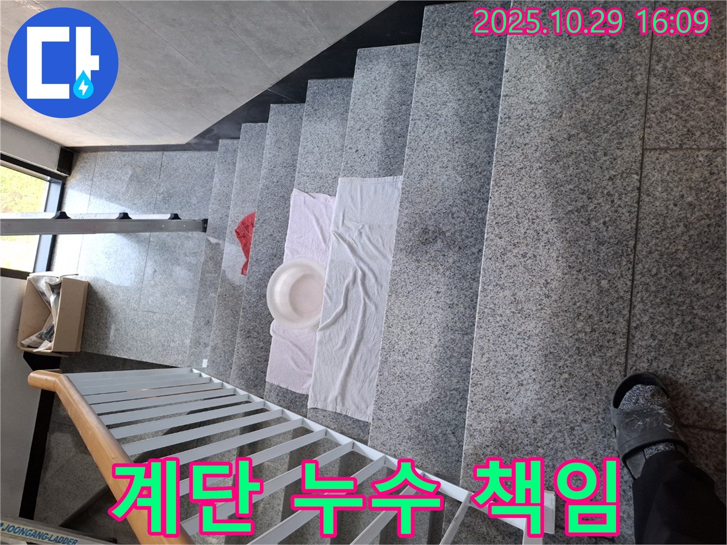계단에 놓인 수건과 대야 - 누수 문제에 대한 책임감을 보여줍니다.