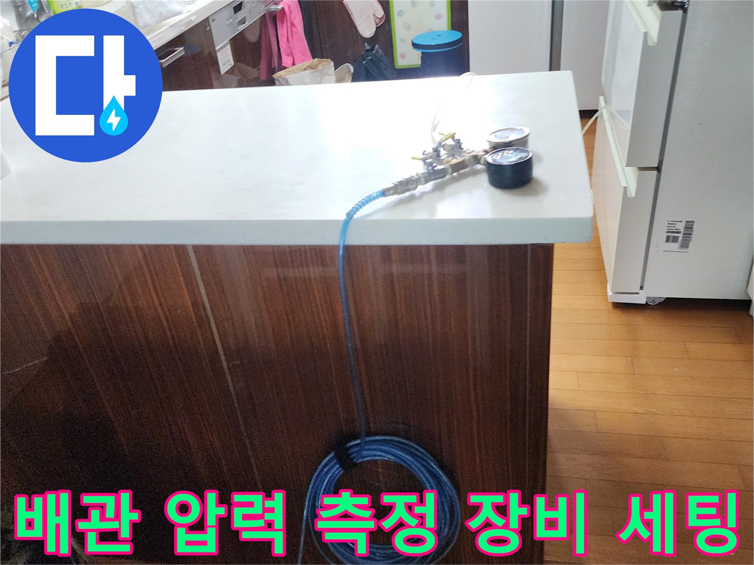 조리대 위에 놓인 파란색 호스와 디지털 게이지