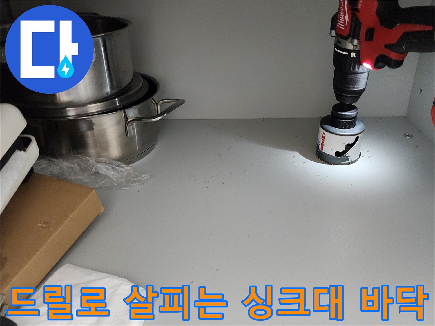 싱크대 하부장 구석을 드릴로 점검하는 작업 사진