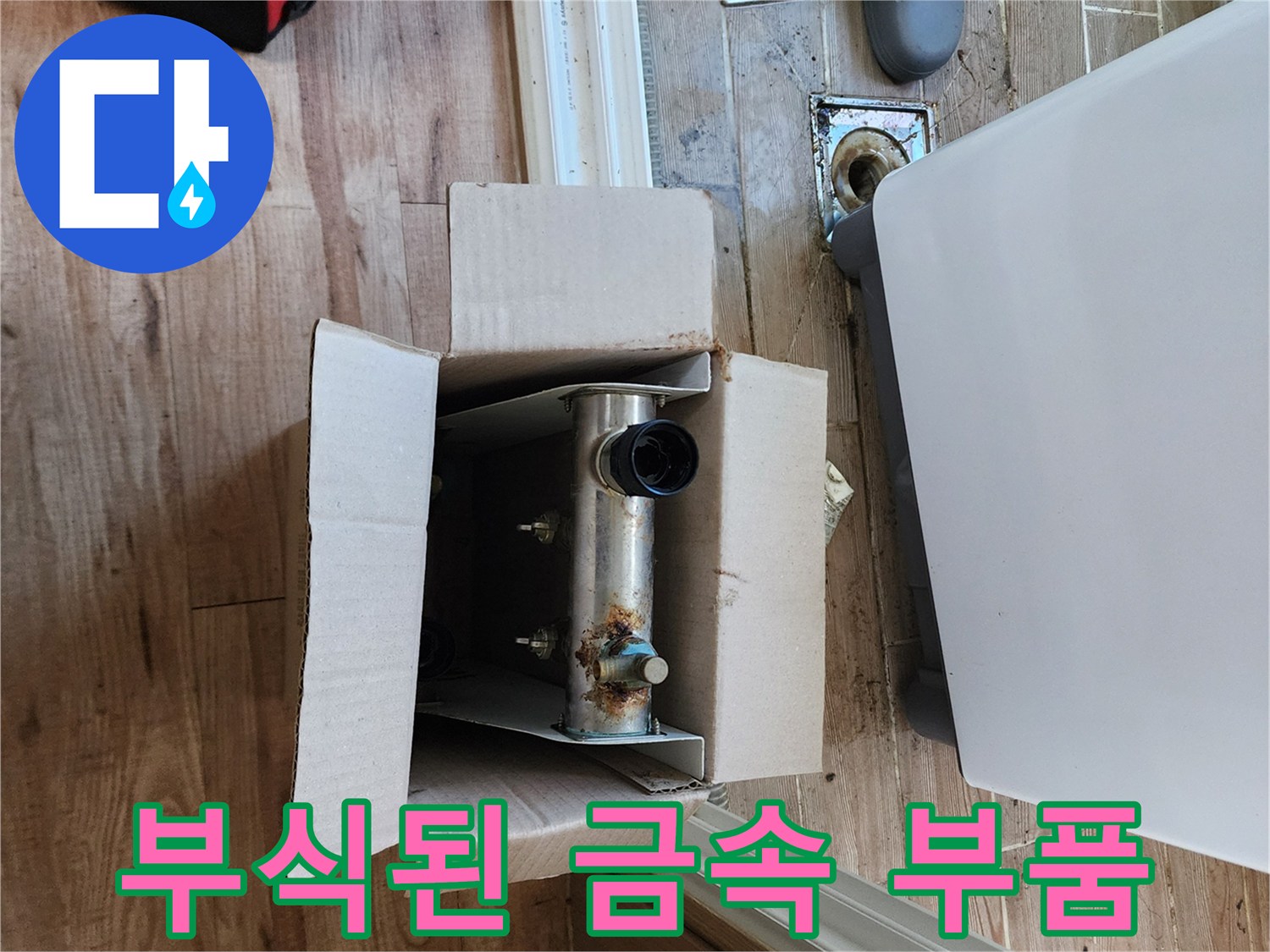박스 안에 놓인 녹슨 배관 연결 부위의 상세 사진