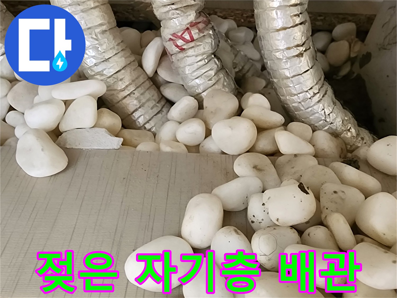 물샘으로 인해 젖어 있는 배관과 자갈