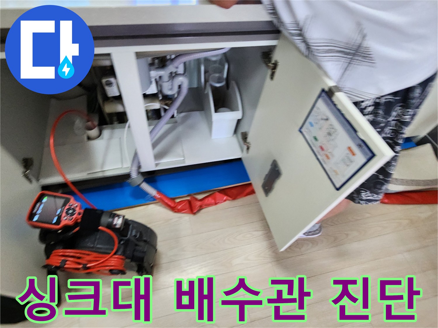 싱크대 하부장-배수 호스와 연결된 배관을 정밀하게 점검하는 장면