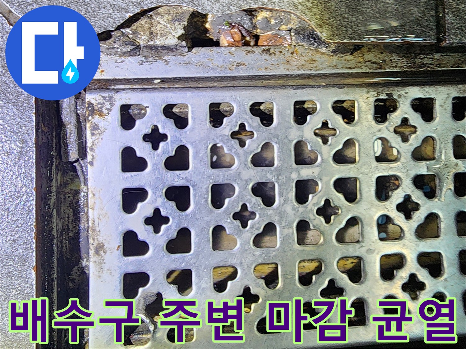 금속 배수구 덮개와 깨진 타일 사이의 습기 노출 부위