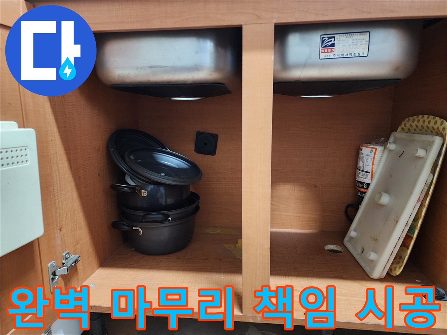 싱크대 하부장 내부 - 누수 부위를 찾기 위해 꼼꼼하게 살펴보고 있습니다.
