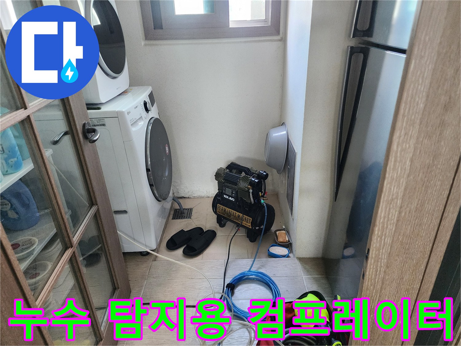 건조기와 세탁기 사이 공간에 설치된 검은색 압력 테스트 장비