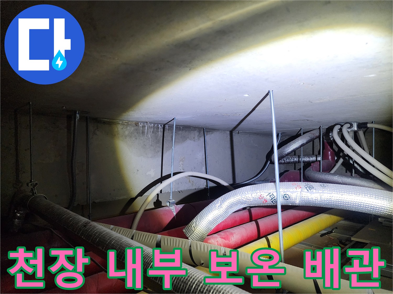 보온재로 감싸진 은색 및 노란색 배관의 배열