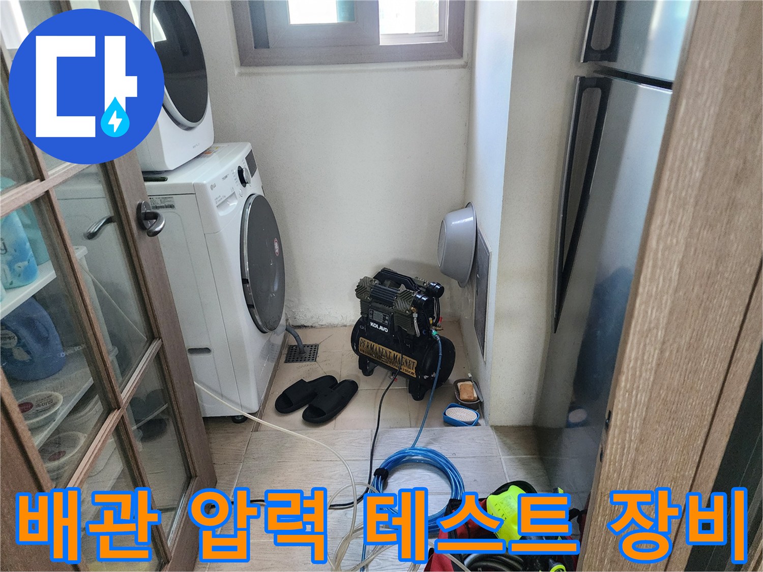 세탁기와 냉장고 사이 좁은 공간에 설치된 공기 압축기 및 점검 호스
