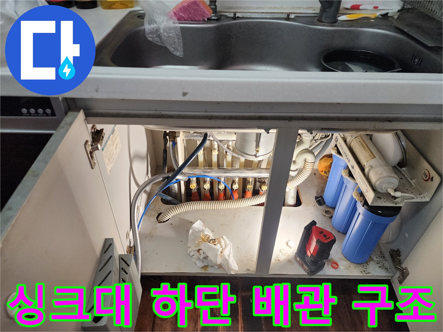 싱크대 하부의 정수기 필터 및 각종 수도 연결 호스들의 복잡한 모습