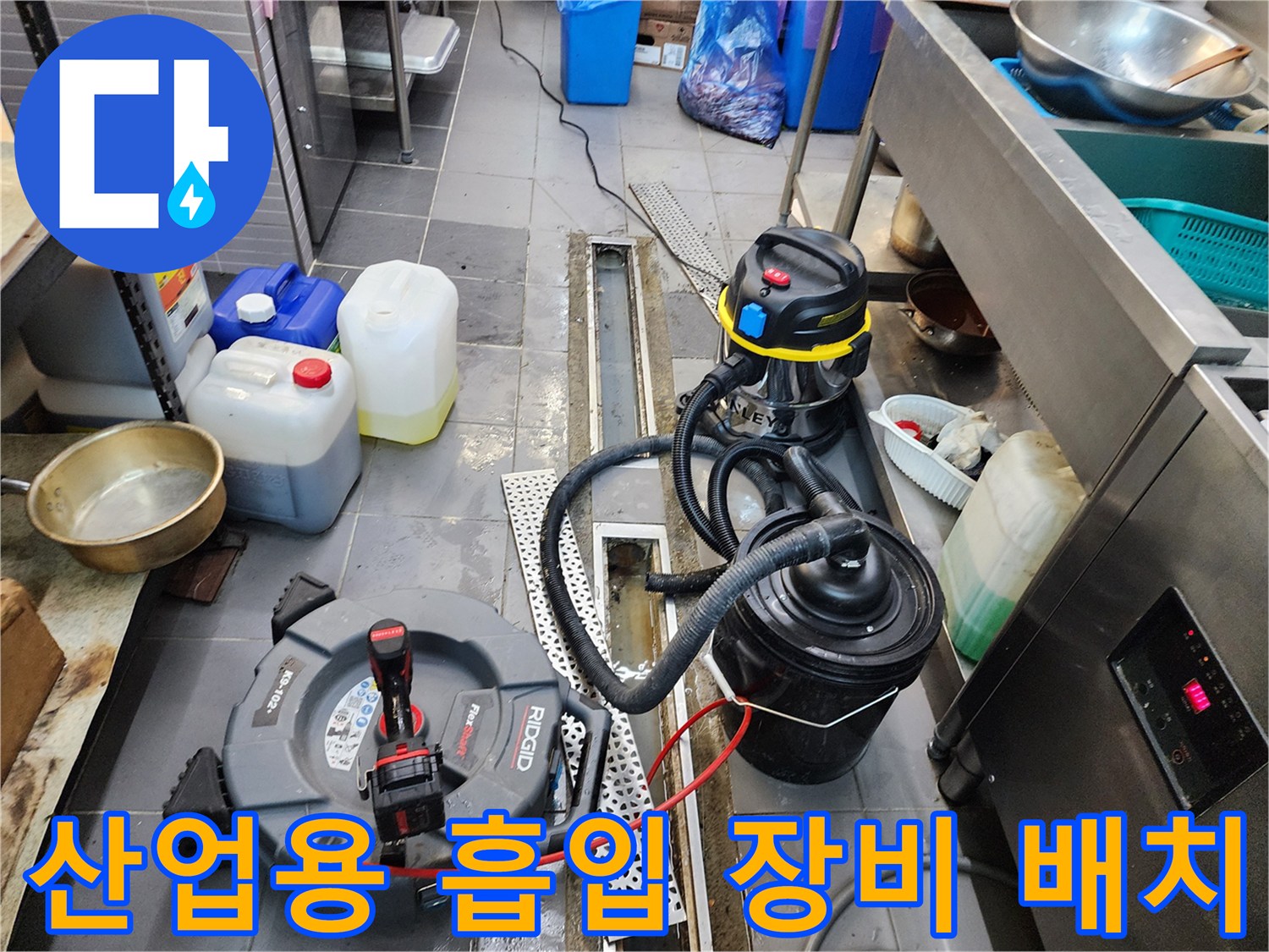 배관 청소를 위해 트렌치 근처에 설치된 검은색 습식 진공 흡입기
