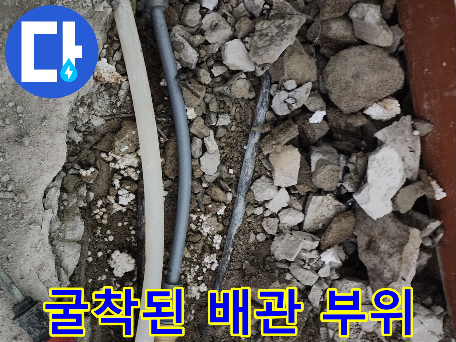 바닥 파쇄 후 드러난 젖은 흙과 수도 배관