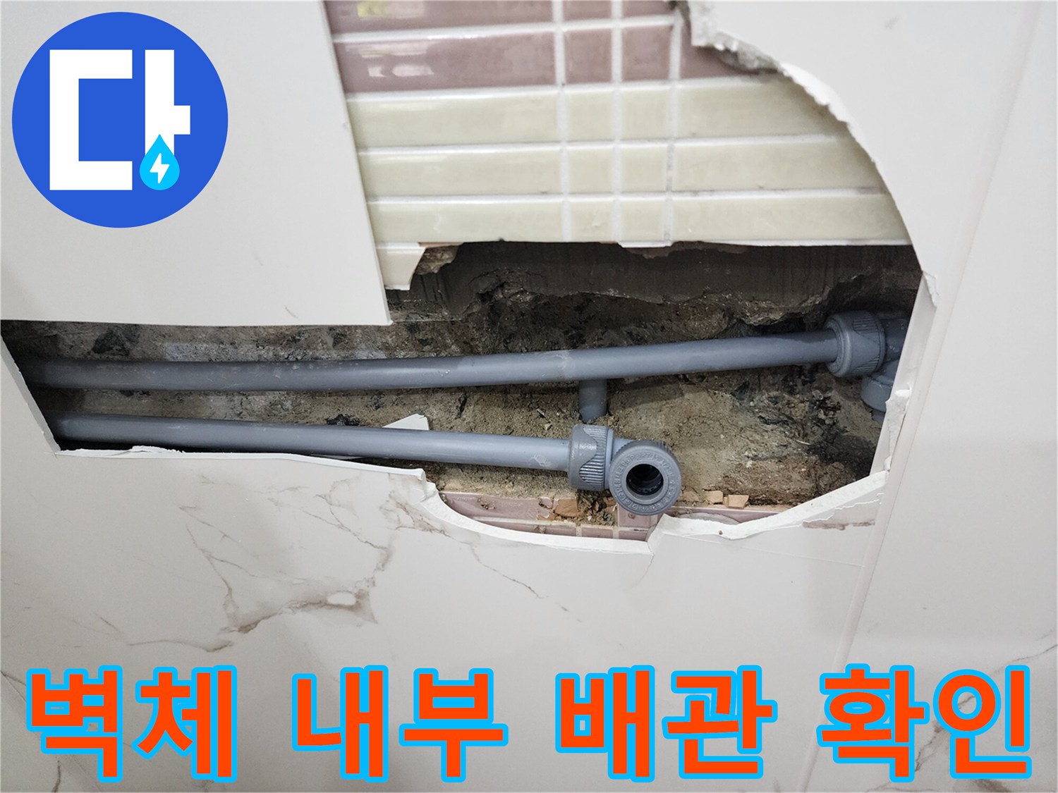 타일 제거 후 노출된 회색 수도 연결 배관