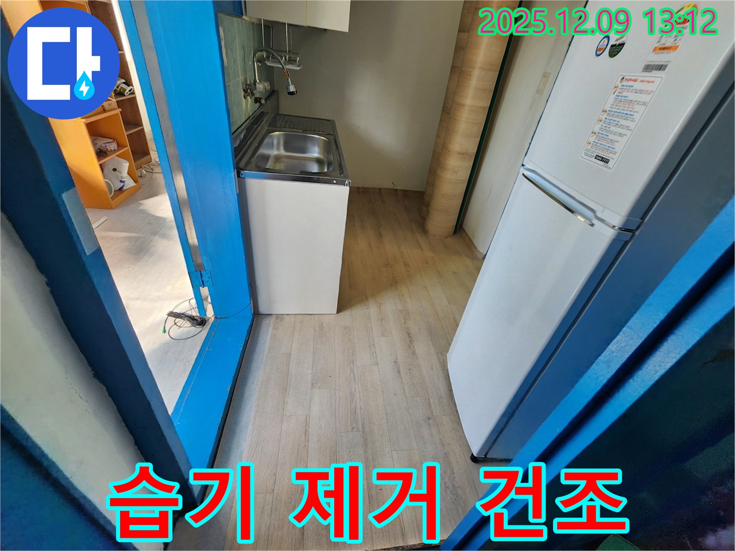성동리 - 싱크대 하부장 내부 습기 제거 및 건조 작업을 진행하고 있습니다.