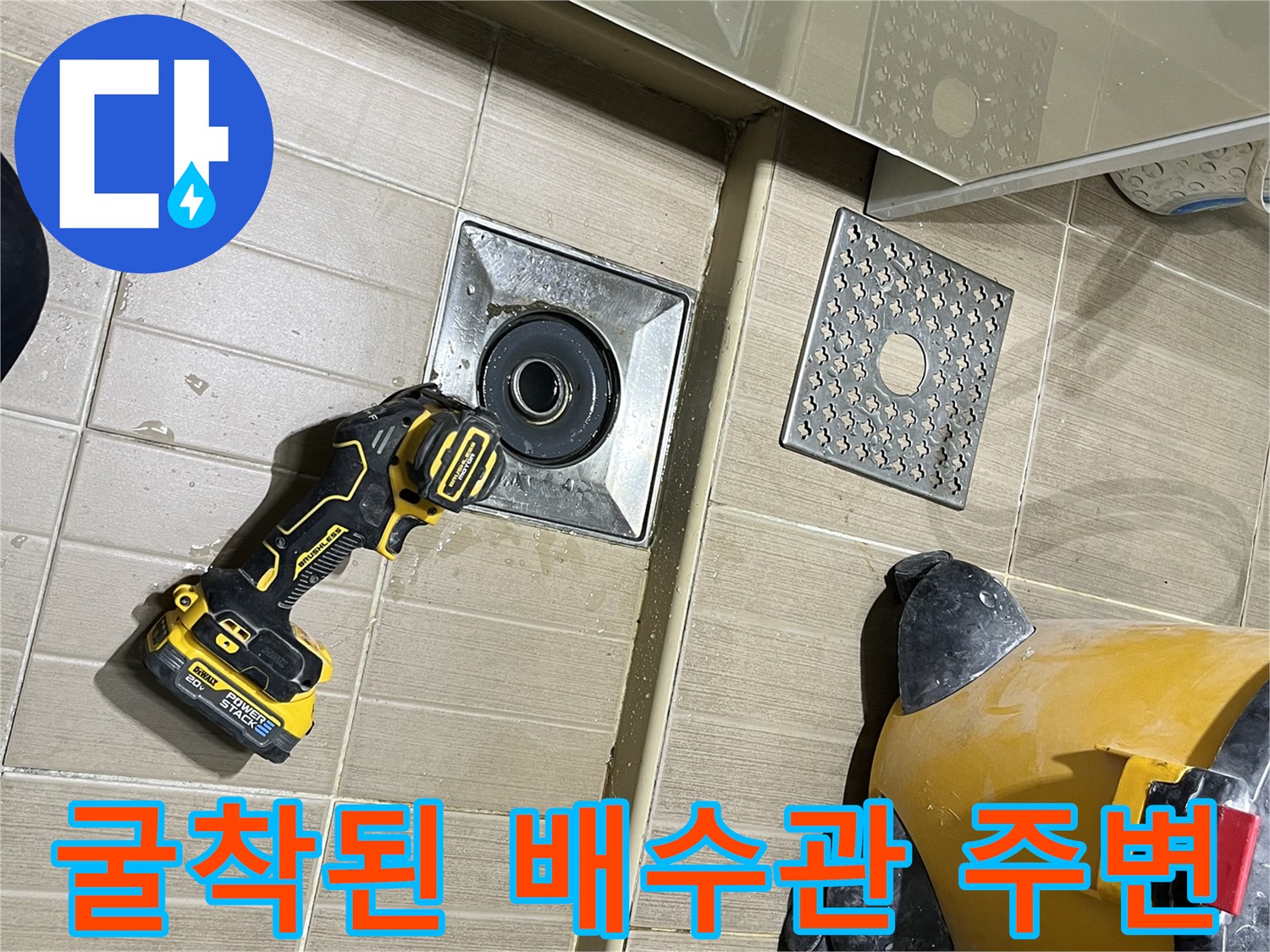 타일 제거 후 드러난 하수구 트랩과 현장 청소 장비