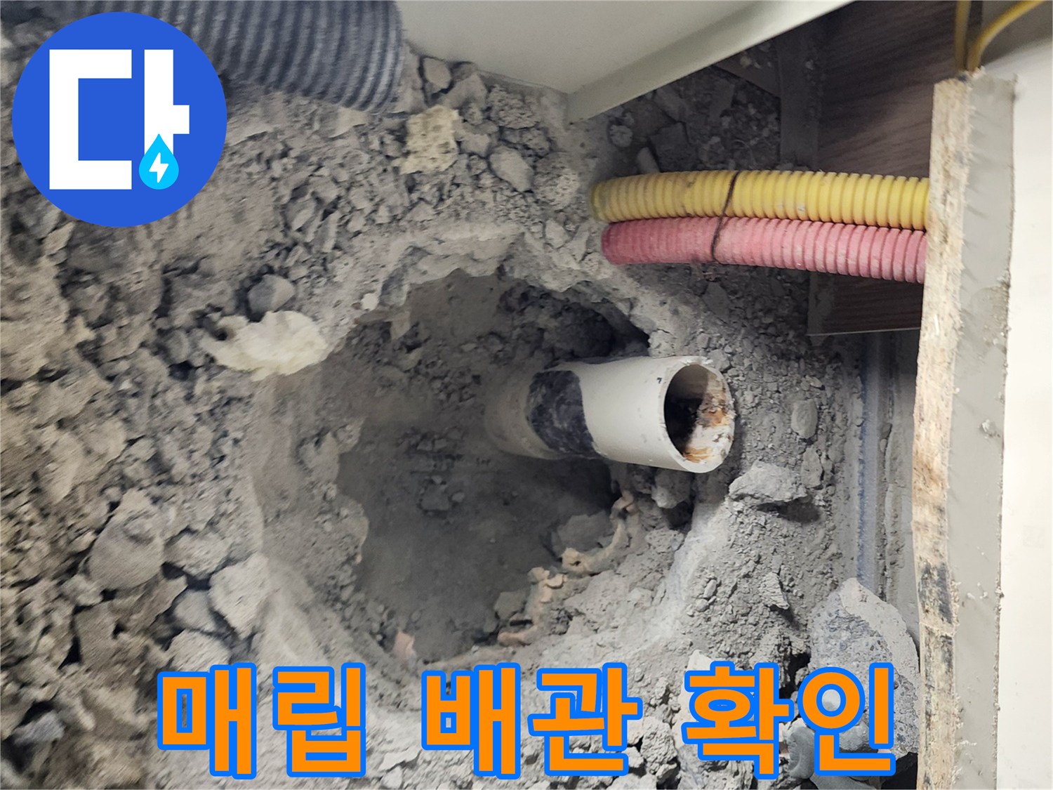 콘크리트 층을 파헤쳐 드러난 하얀색 매립 배선과 잔해물