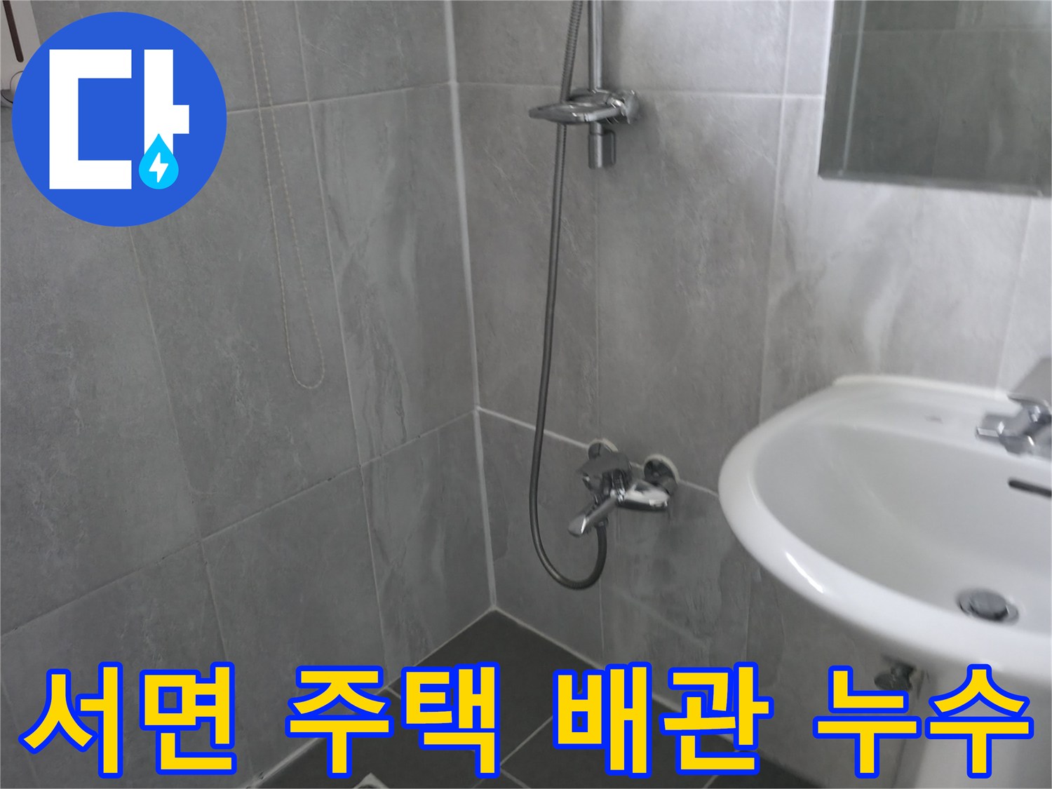 회색 타일 벽면과 바닥이 돋보이는 욕실-샤워기와 세면대-누수 원인 파악에 집중