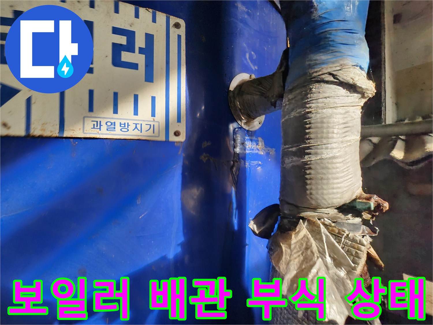 파란색 전기 보일러 본체와 부식된 연결 배관의 모습