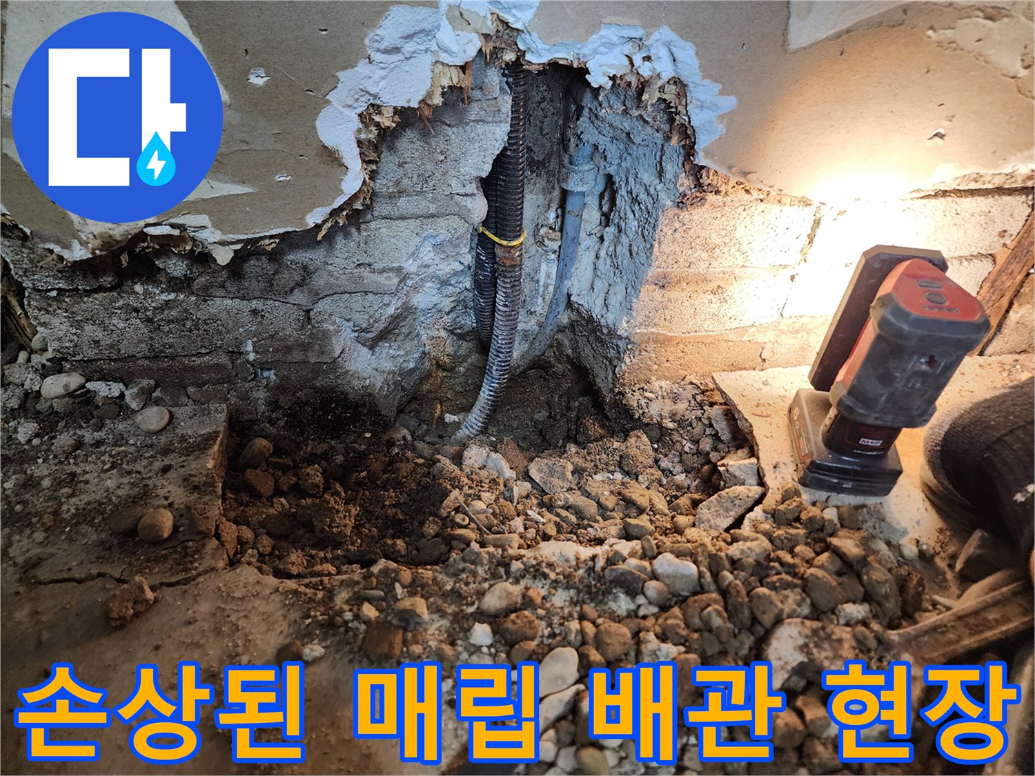 물에 젖은 자갈층 사이의 파손된 검정색 배관