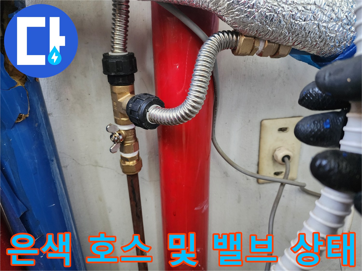 배관 연결 부위의 금속 소재 부속과 은색 호스 상세 사진