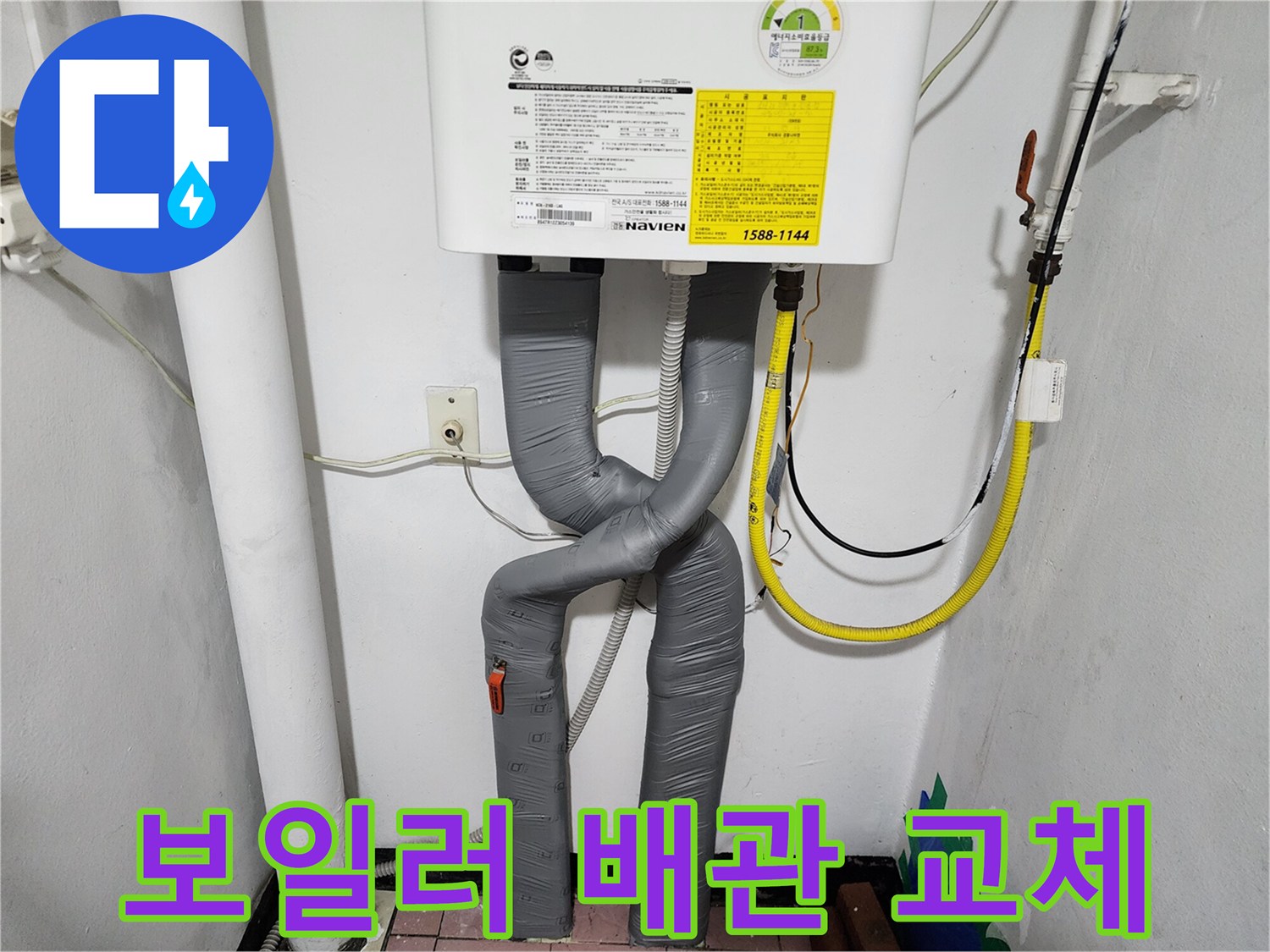 보일러 하단에 새롭게 설치된 회색 주름관 배관 모습