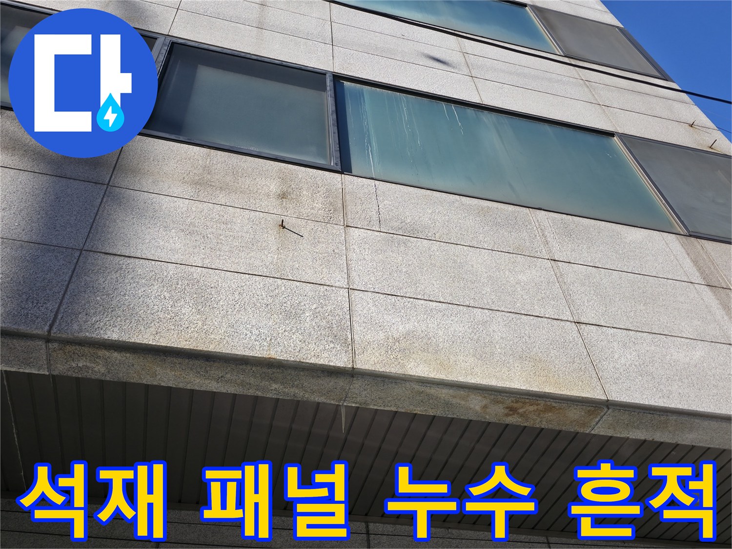 상가 건물 석재 외벽-패널 사이의 젖은 자국과 얼룩