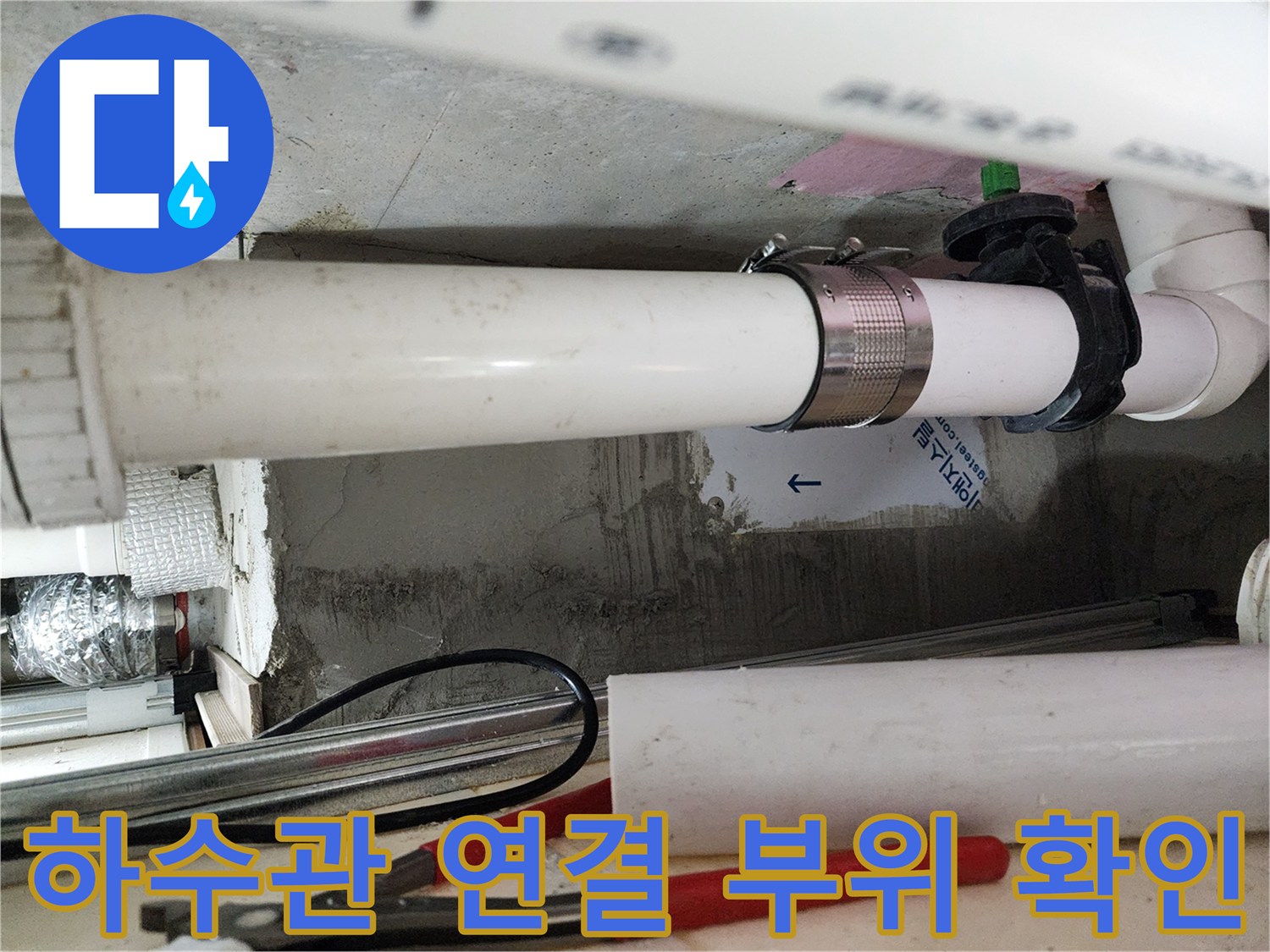 천장 내부의 흰색 PVC 배관과 금속 고정 장치 사진