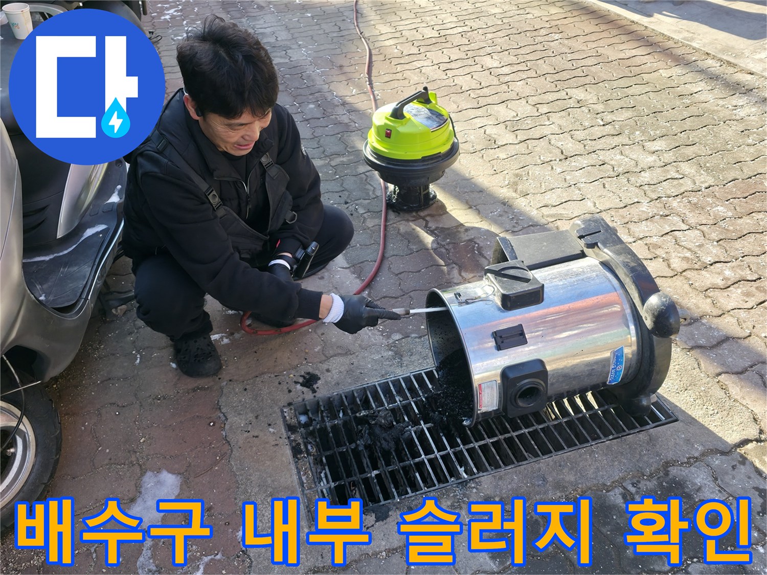 하수구 틈새에 쌓인 검은색 오물을 제거하는 현장 모습