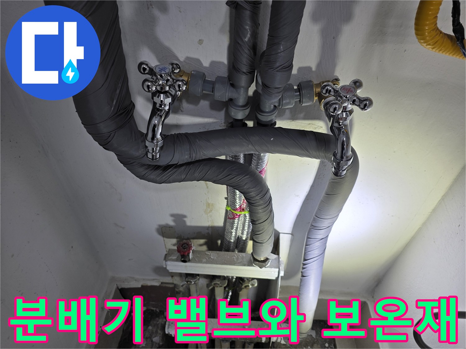 금속 재질의 분배기 밸브와 검은색 배관 마감재 사진