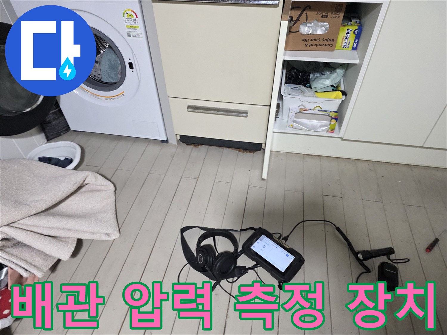 세탁기 옆 바닥에 배치된 전문 검측 장비