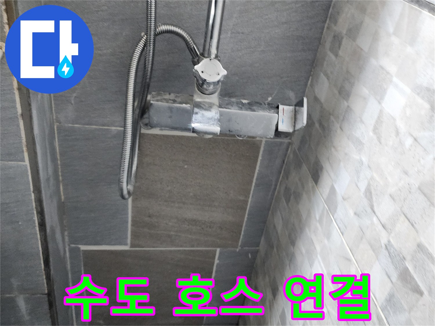 욕실 벽면 타일과 수전 연결 배관의 근접 사진