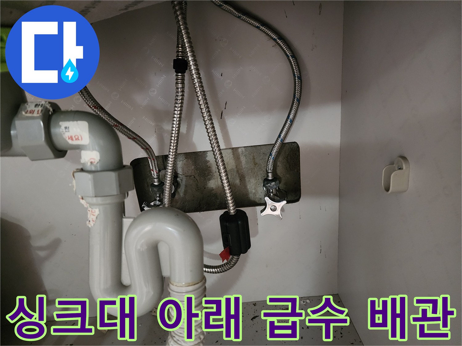 벽면-고정판과-연결된-금속제-급수-호스