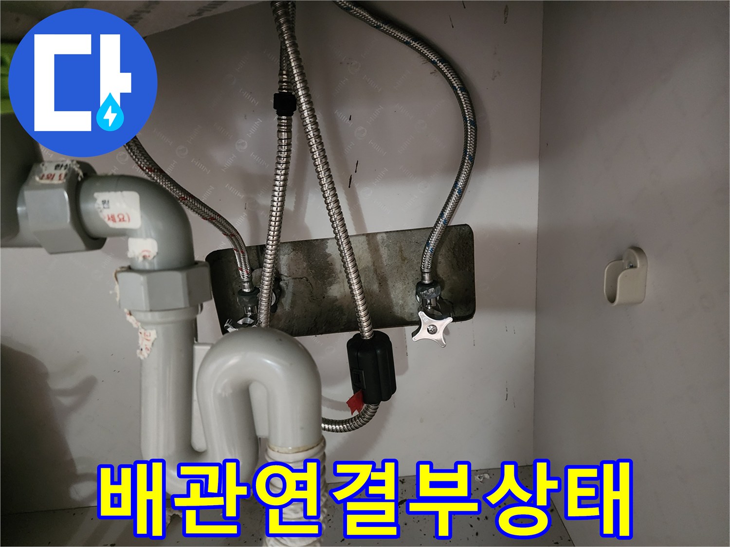 싱크대 아래 수도 밸브와 금속 호스 연결 상태