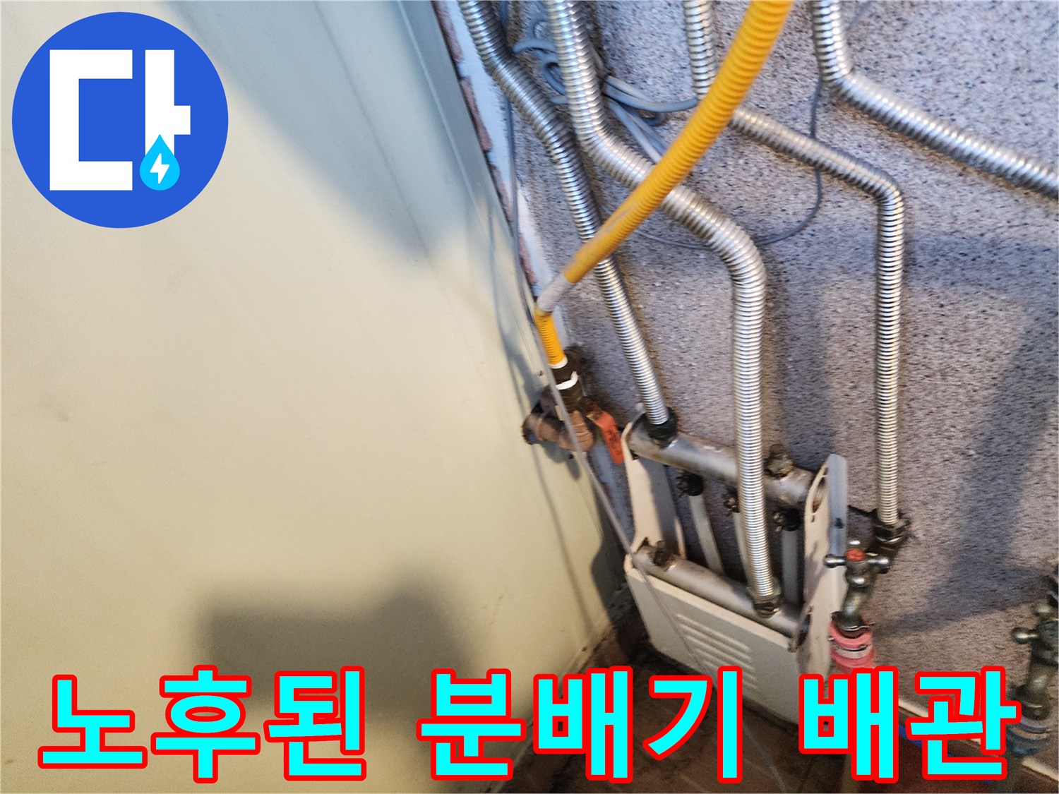 복잡한 구조의 은색 주름관과 노란 호스가 연결된 배관 설비 사진