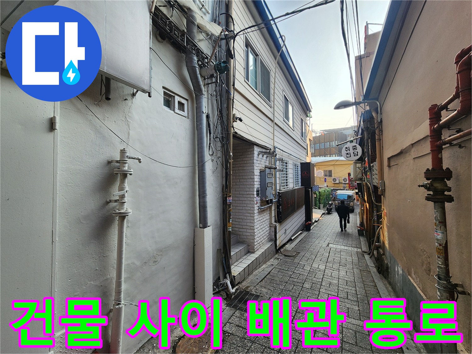 좁은 건물 사이 공간에 설치된 외부 급수 배관
