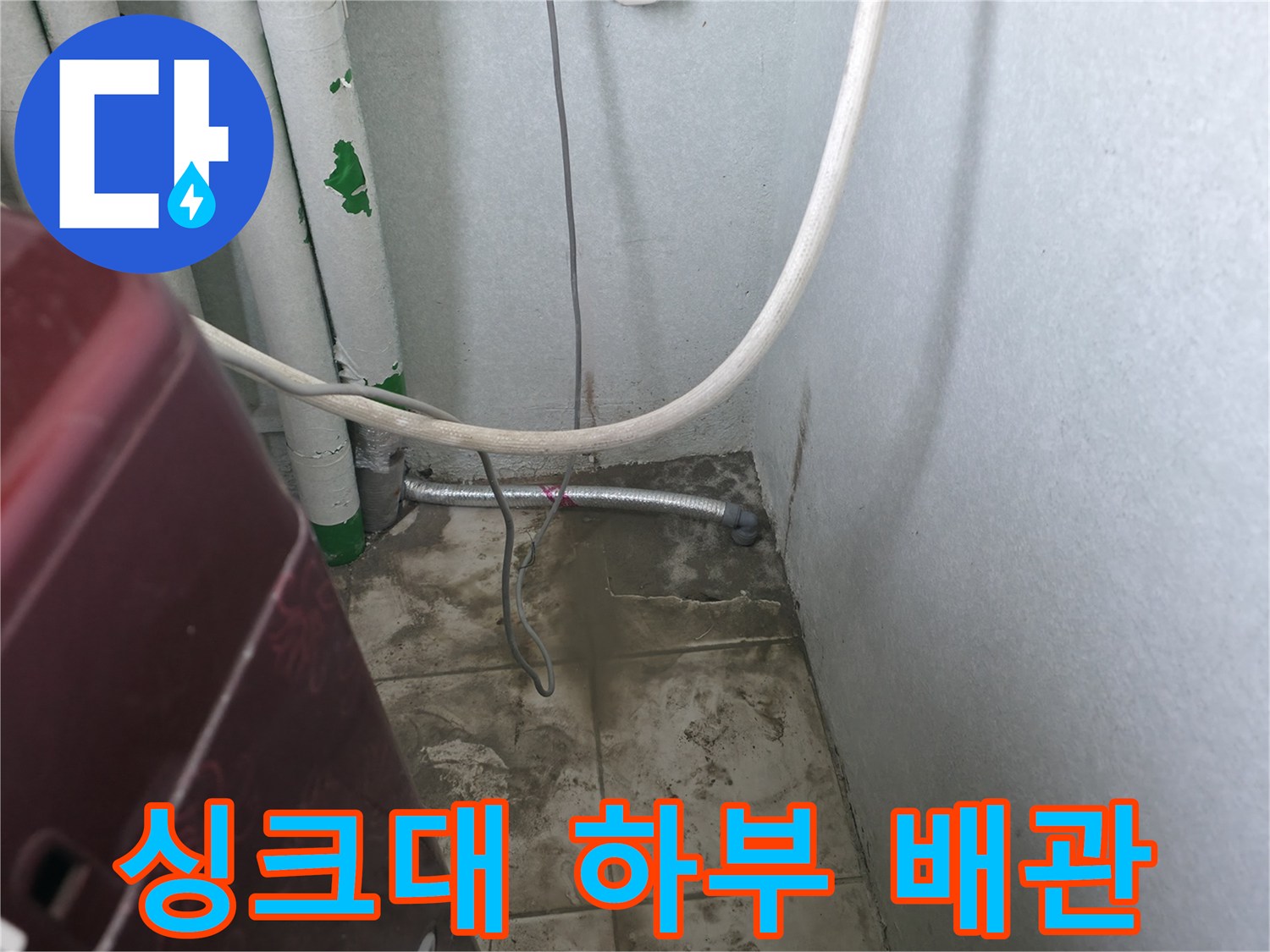 하부장 안쪽의 수직 배관과 가로로 연결된 금속관 사진입니다.