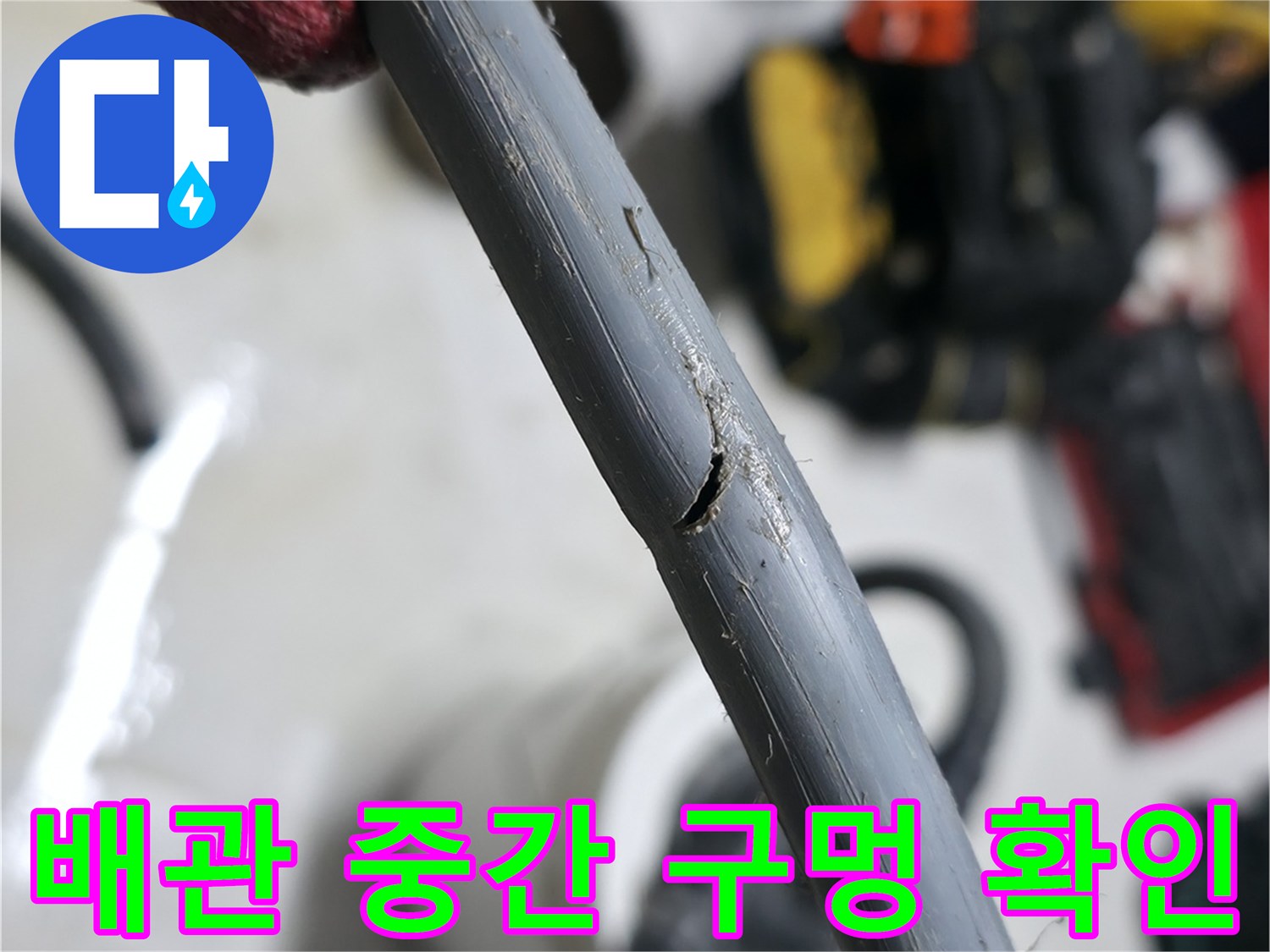 작업자가-확인하고-있는-세탁기-배수-호스의-파손된-부분