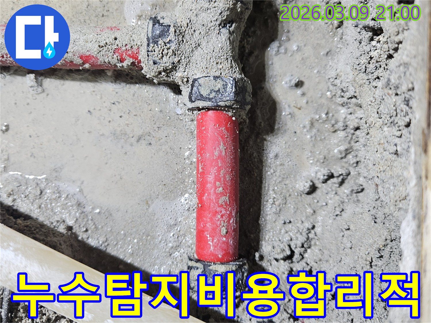 젖은 시멘트 바닥에-매립된 빨간색 배관의-누수 지점을-정확히 찾아내어-보수한 모습입니다