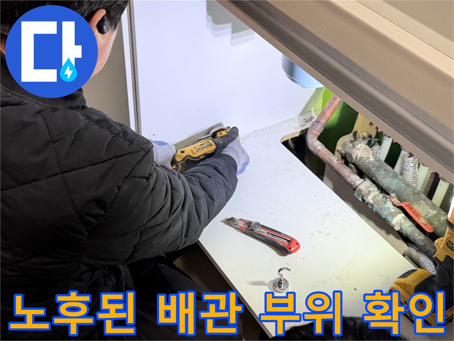 싱크대 하단 공간에 노출된 동배관과 작업용 칼