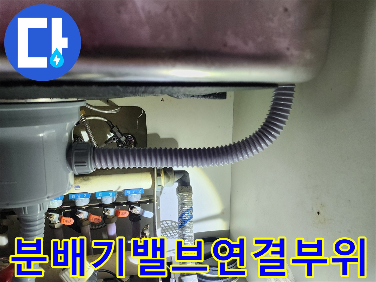 노후된 분배기 밸브와 주름관 연결 부위의 상세 사진입니다.