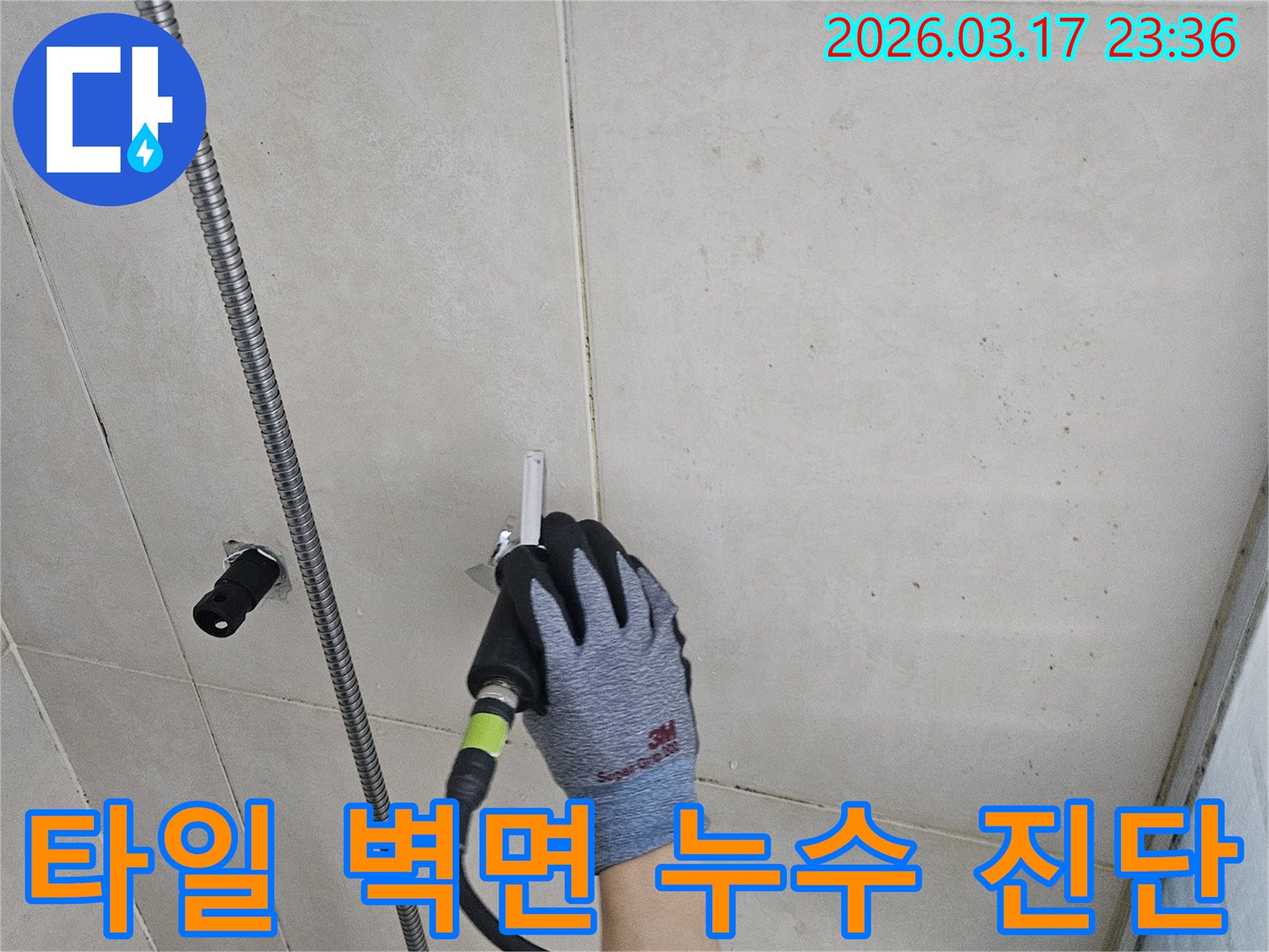 전문 엔지니어가-누수 탐지 장비로-타일 벽면의 배관 누수 여부를 확인하는 중입니다