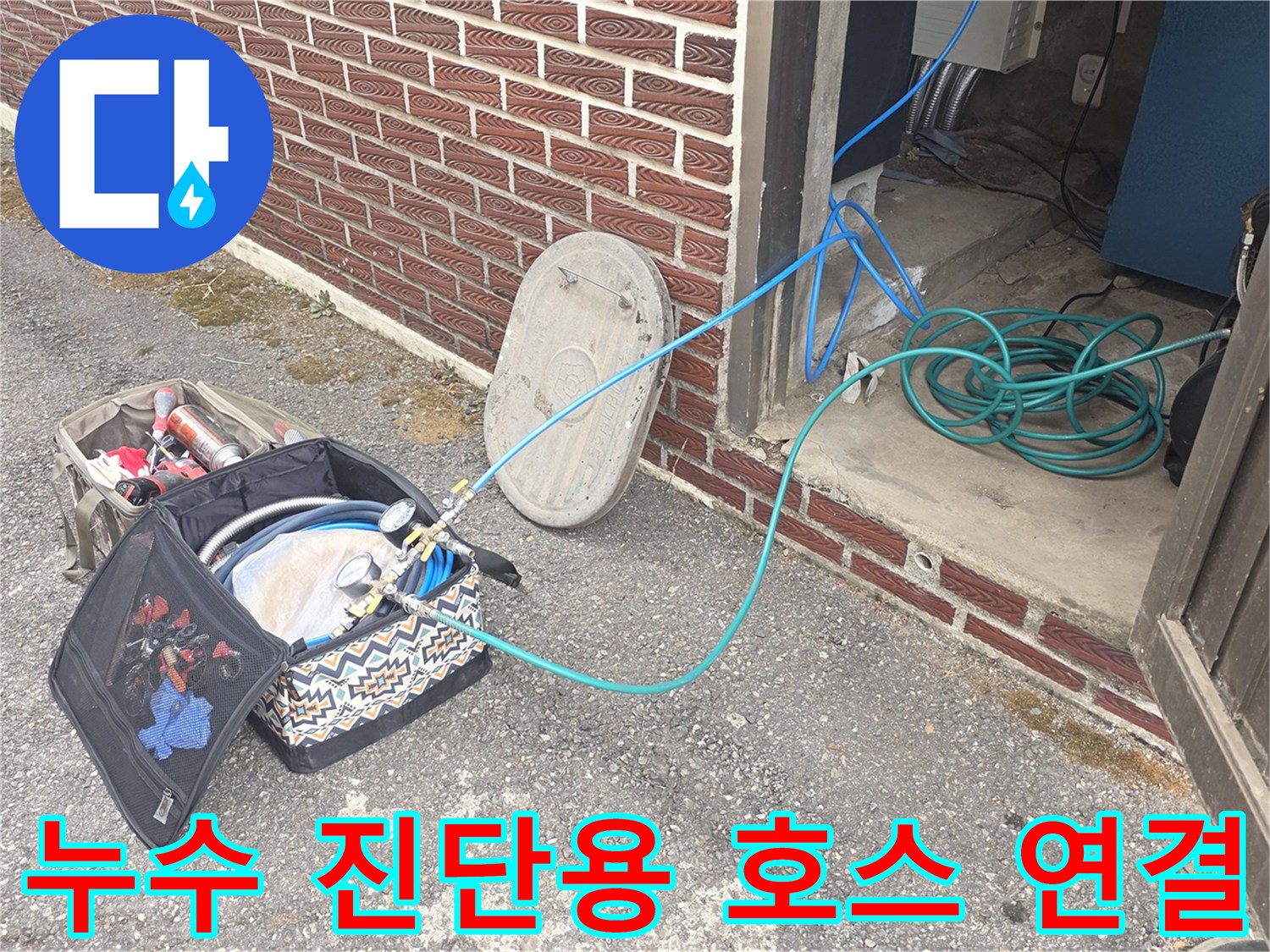 현장 바닥에 놓인-누수 검사용 장비와-연결된 파란색 호스