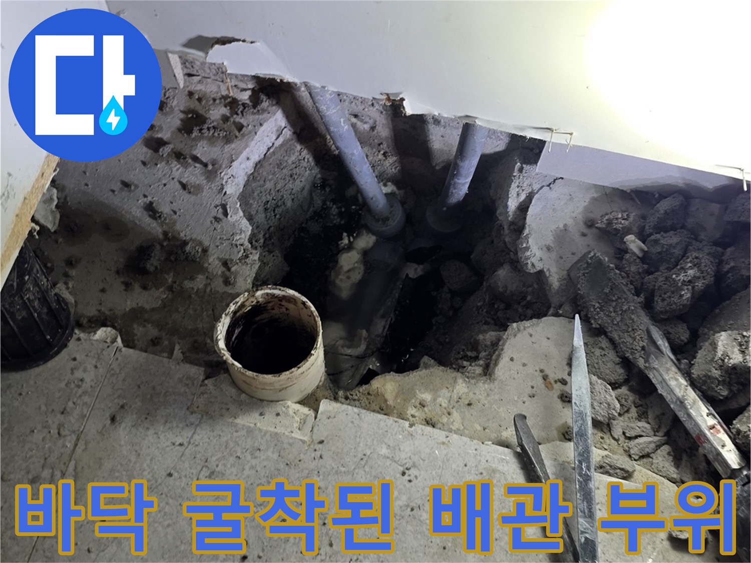 싱크대 하부장 아래-노출된 PVC 배관과 주변 자재들