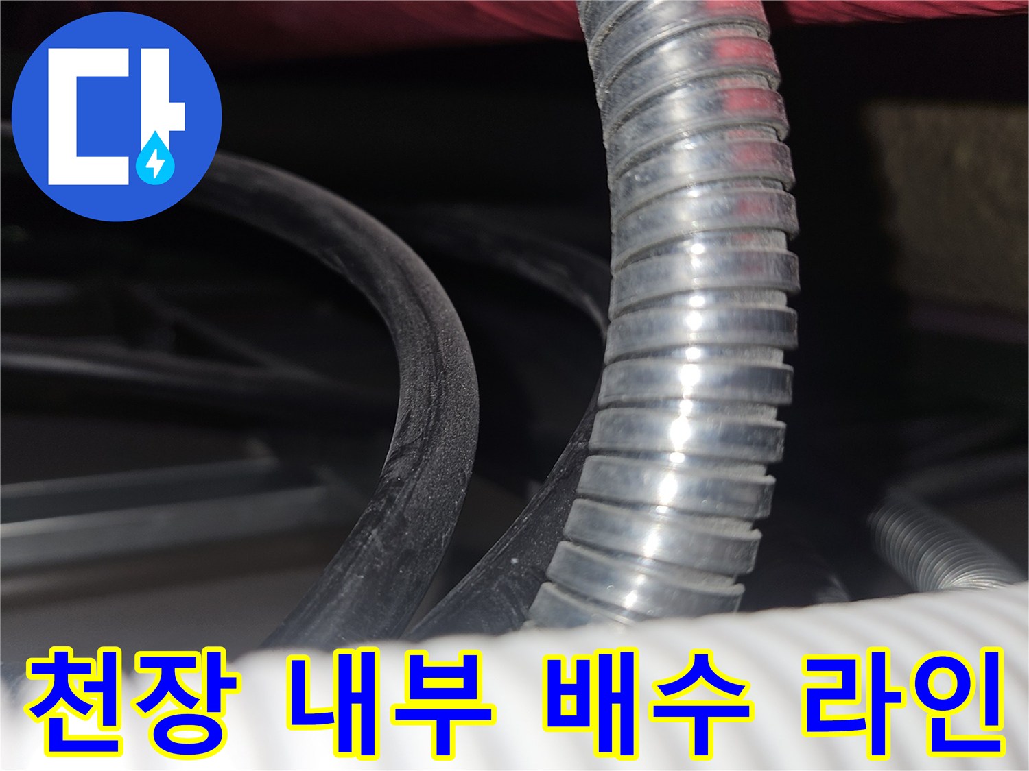 은색 주름관과 흰색 대형 배관이 겹쳐진 천장 모습