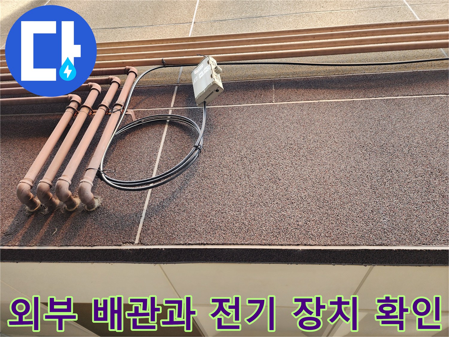 갈색 배관과 검은 전선이 연결된 외벽 모습