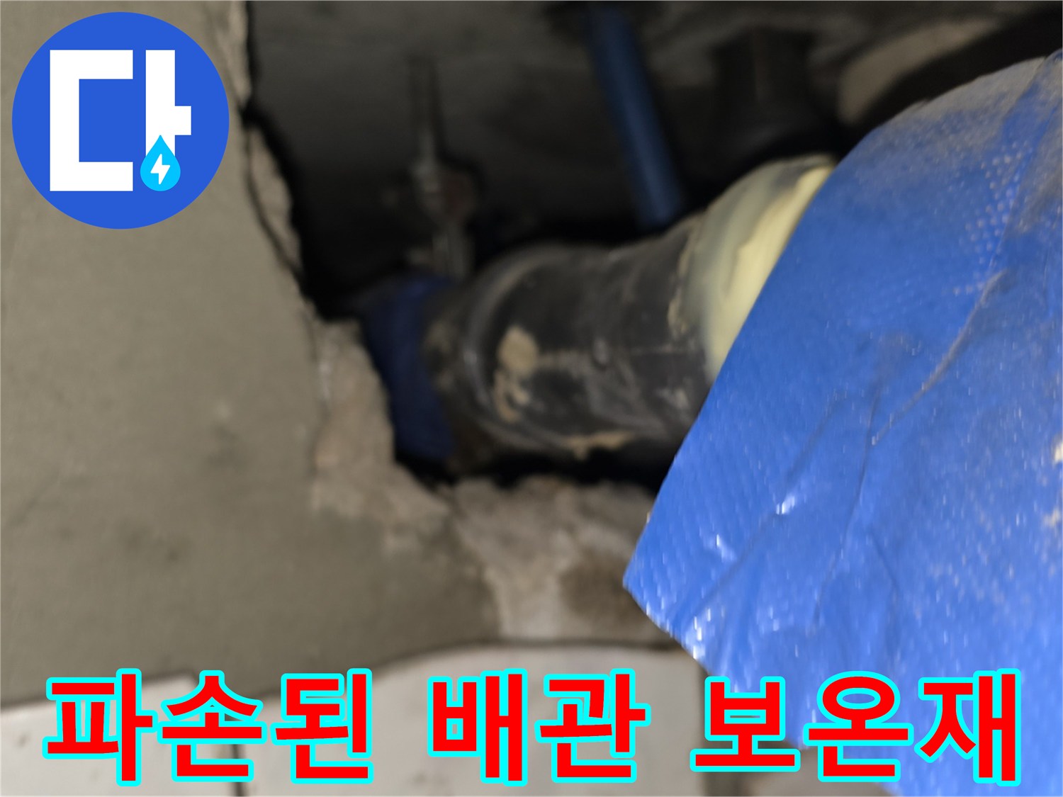 찢어진 파란색 보온재 사이로 노출된 배관 연결 부위