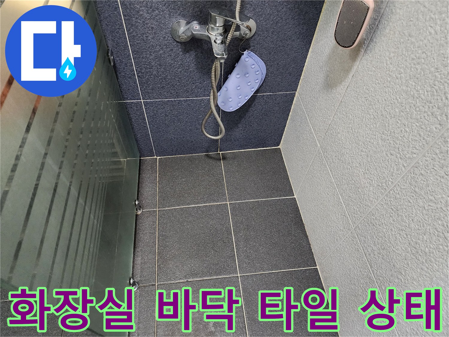 어두운 색상의 욕실 타일과 샤워기 수전 모습