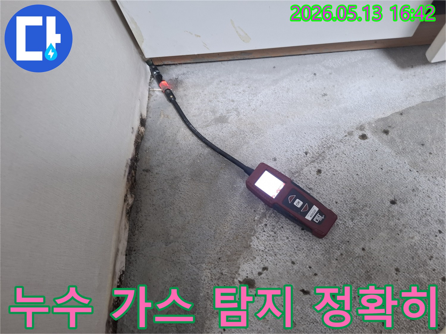 벽면과 바닥의 접합부에서-누수 탐지 장비로 가스 유출 여부를 확인하는 모습입니다.