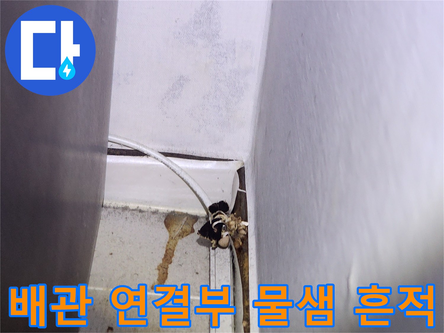 배관 주변 콘크리트 벽면의 젖은 얼룩 사진